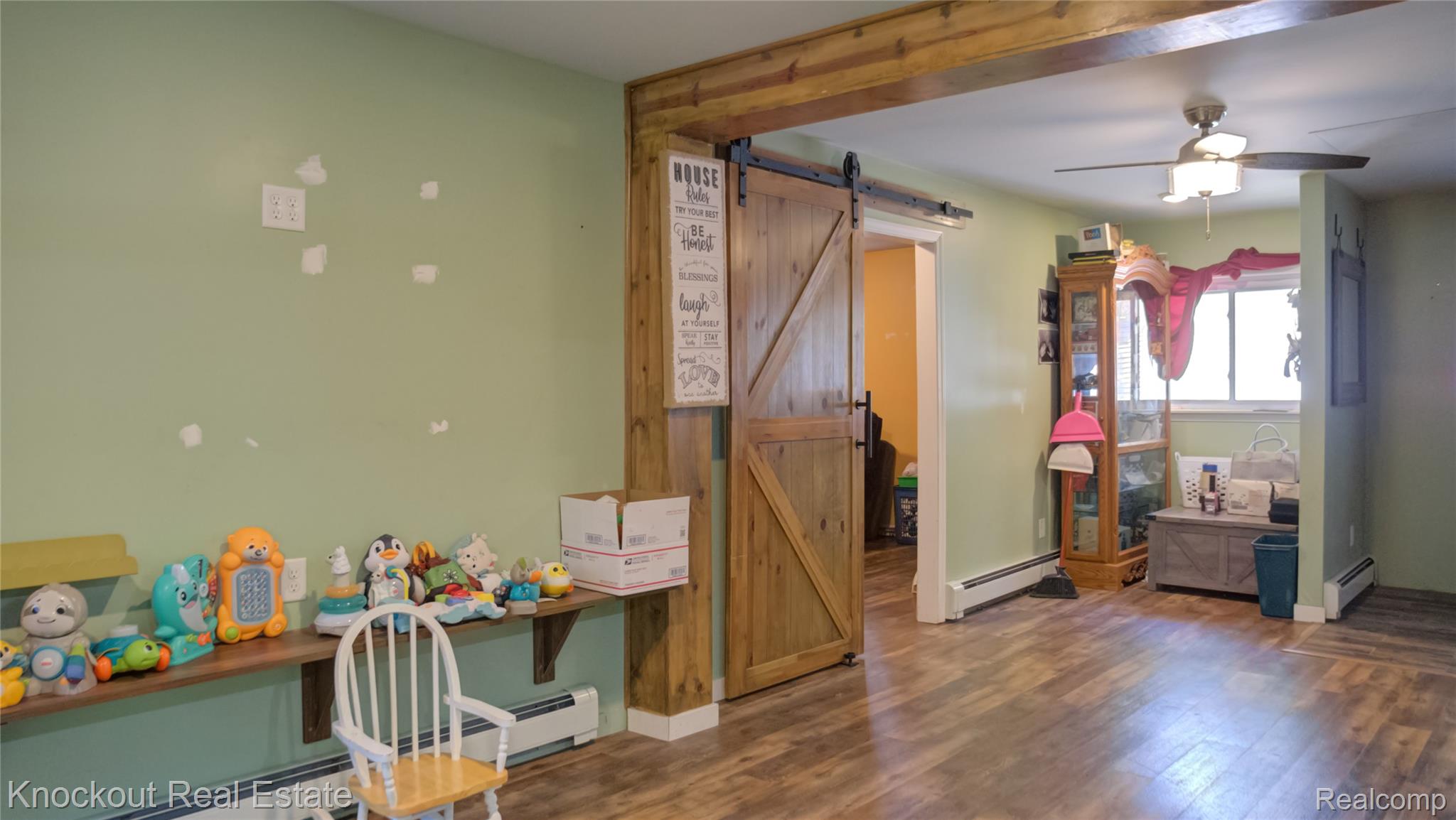 4195 Williamson Road Saginaw, MI 48601 - Photo 5 of 50 Wood-finish flooring throughout, featuring a natural wood-toned barn door and exposed ceiling beam