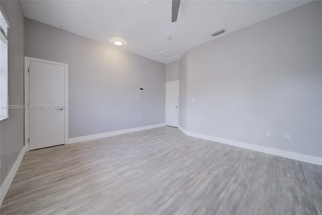 a view of an empty room with wooden floor