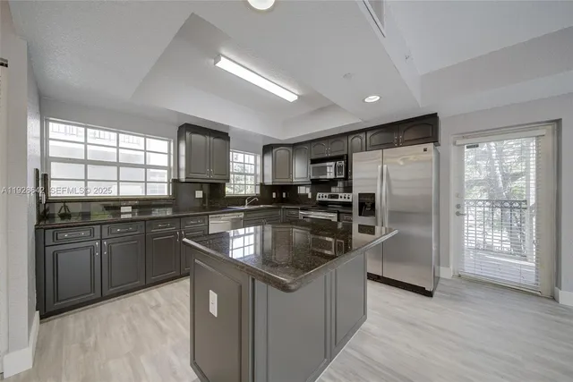 a kitchen with stainless steel appliances granite countertop a sink stove and refrigerator