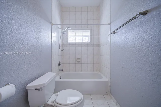 a bathroom with a toilet bathtub window and shower