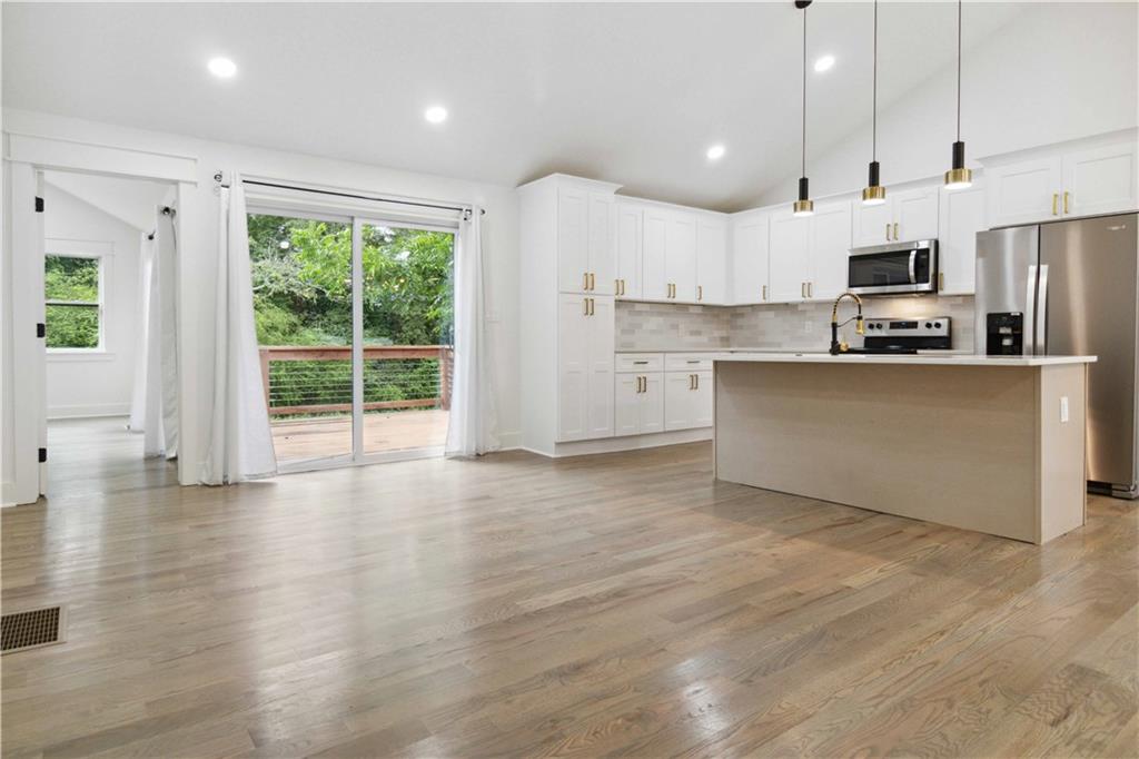 3435 Maplehurst Drive Decatur, GA 30032 - Photo 8 of 39 a open kitchen with stainless steel appliances granite countertop a refrigerator oven a sink dishwasher and white cabinets with wooden floor