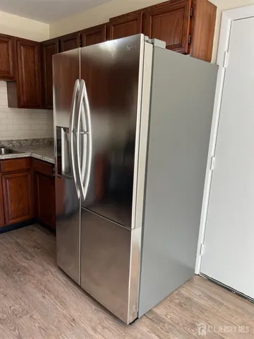 a kitchen with granite countertop a refrigerator a sink and dishwasher