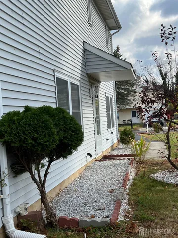 a view of a house with a yard and large tree