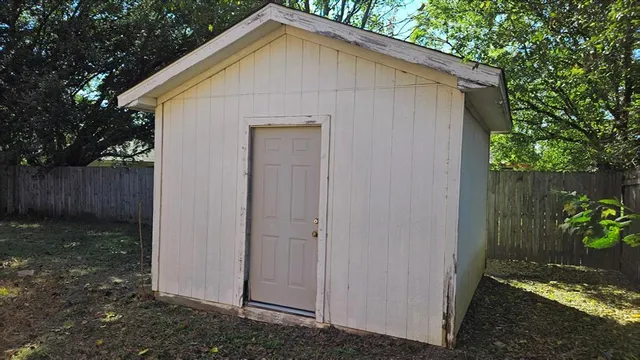 a view of backyard of house with wooden fence