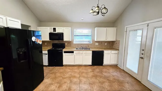 a kitchen with a refrigerator and a stove top oven