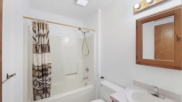 a backyard of a house with table and chairs plants and large tree