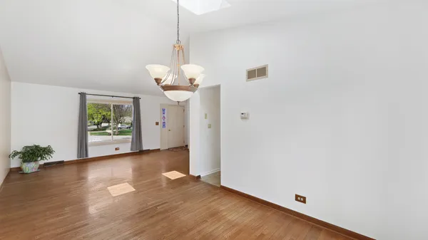 a view of a room with wooden floor and a chandelier