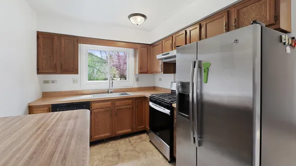a kitchen with stainless steel appliances granite countertop a refrigerator and a sink