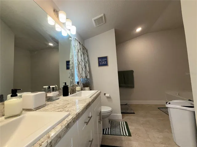 a bathroom with a sink a toilet and a mirror