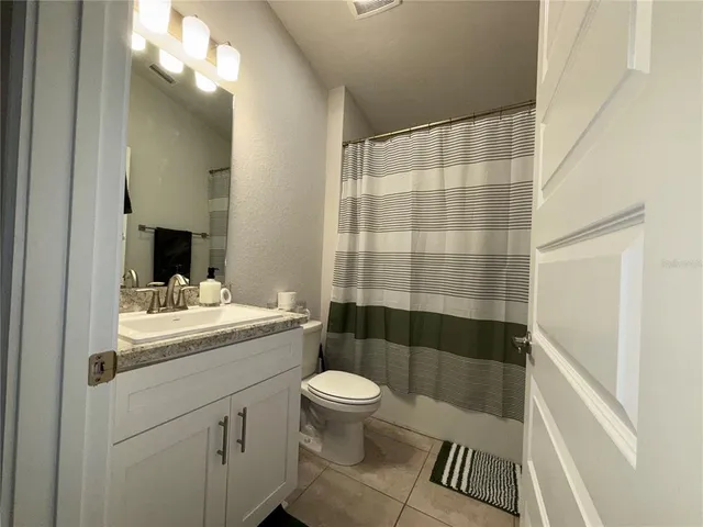 a bathroom with a sink a toilet a mirror and shower