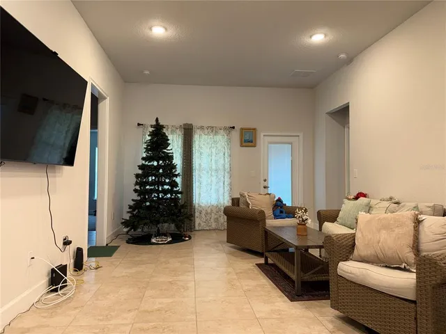 a living room with furniture a flat screen tv and a window