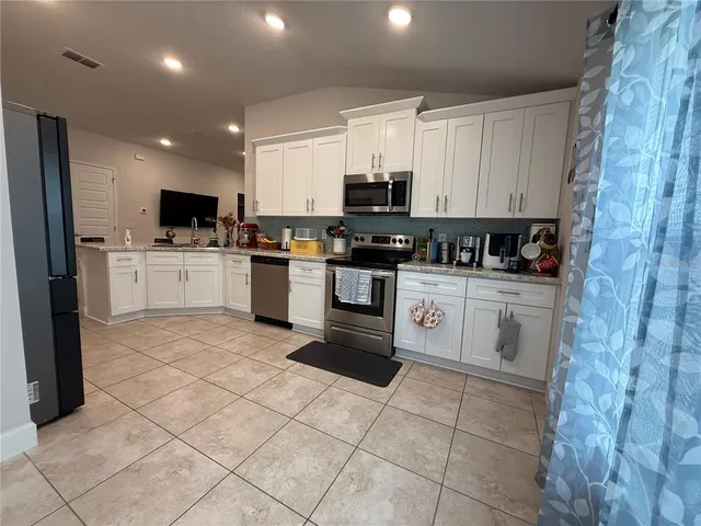 a kitchen with stainless steel appliances a stove sink microwave and cabinets