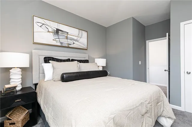 a bedroom with a bed and painting on the wall