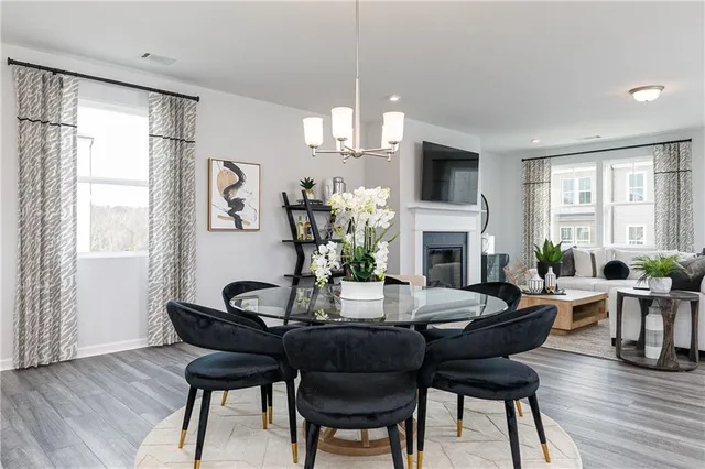 a dining room with furniture a chandelier and wooden floor