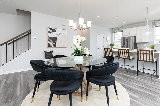 a dining room with furniture a chandelier and wooden floor