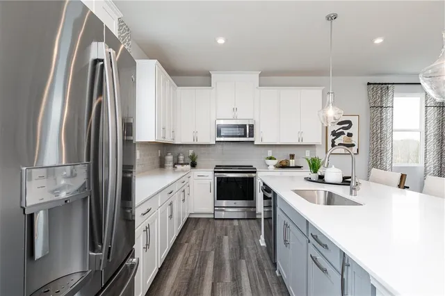 a kitchen with kitchen island a counter top space a sink stainless steel appliances and cabinets