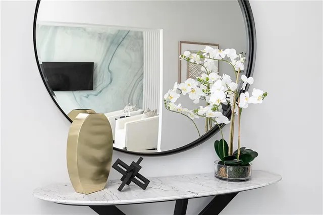 a dining room with wooden floor a glass table and a mirror