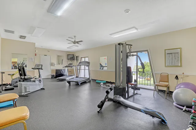a view of a swimming pool with lawn chairs under an umbrella