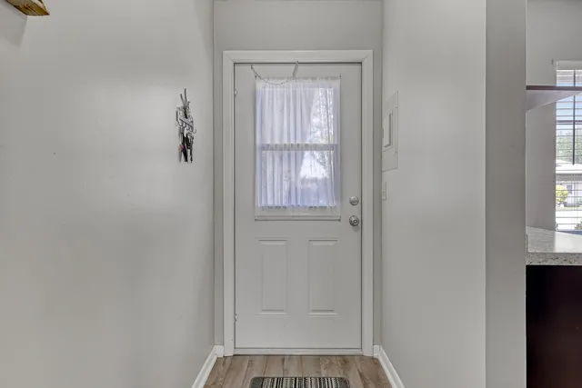 a dining room with furniture a chandelier and wooden floor
