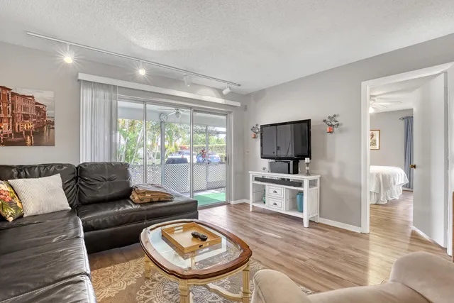 a living room with furniture and a dining table with wooden floor