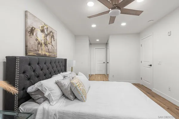 a bedroom with a large bed and a chandelier