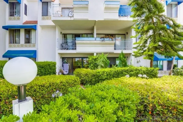 a view of a house with a fountain and potted plants