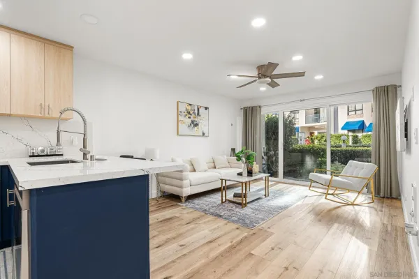 a living room with furniture a large window and wooden floor