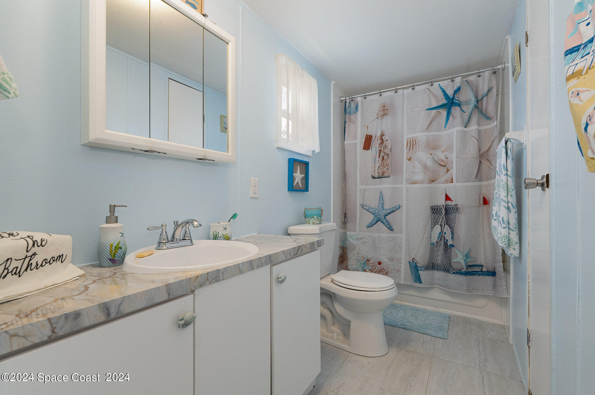 385 Ronald Street Cocoa, FL 32927 - Photo 15 of 24 a bathroom with a granite countertop sink a toilet and a shower