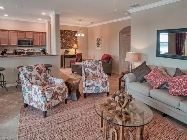 a living room with furniture and a view of kitchen