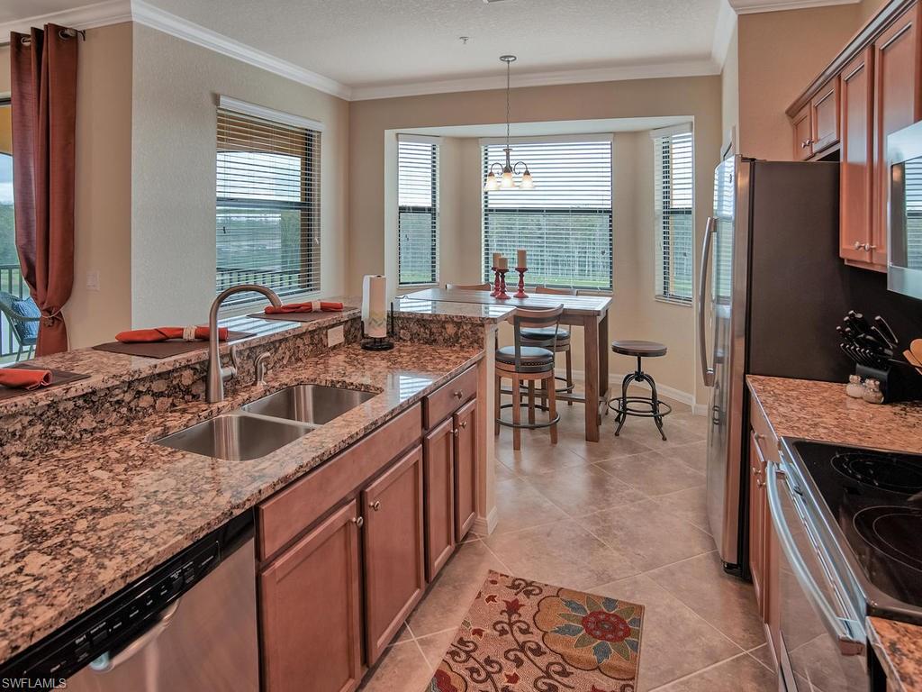 9560 Trevi Court, Unit 4842 Naples, FL 34113 - Photo 6 of 25 a kitchen with stainless steel appliances granite countertop a sink stove and cabinets