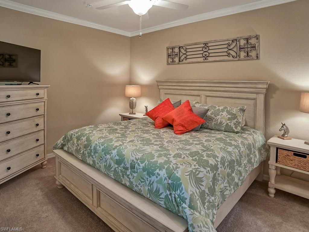 9560 Trevi Court, Unit 4842 Naples, FL 34113 - Photo 9 of 25 a bedroom with a bed and flat screen tv