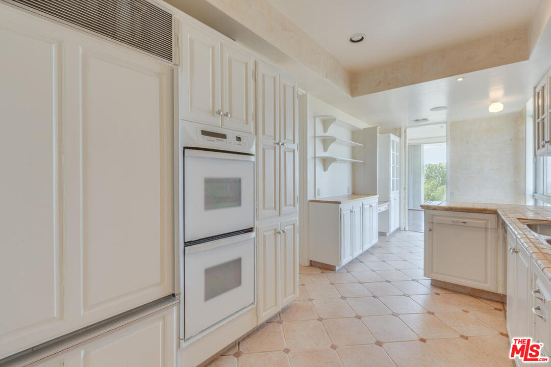 9255 Doheny Road, Unit 902 West Hollywood, CA 90069 - Photo 11 of 47 a view of a kitchen with white cabinets