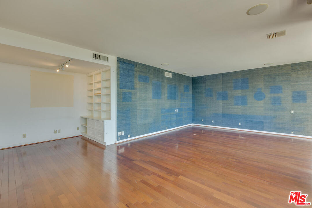 9255 Doheny Road, Unit 902 West Hollywood, CA 90069 - Photo 12 of 47 a view of an empty room with wooden floor and a window