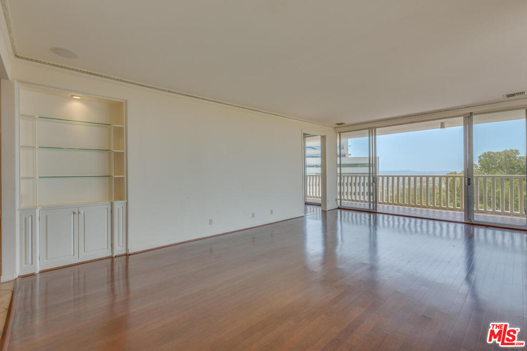 9255 Doheny Road, Unit 902 West Hollywood, CA 90069 - Photo 13 of 47 an empty room with wooden floor and windows