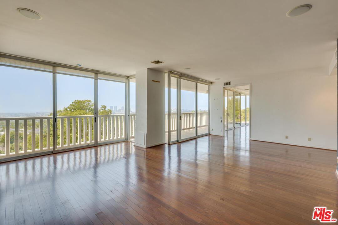 9255 Doheny Road, Unit 902 West Hollywood, CA 90069 - Photo 17 of 47 a view of an empty room with wooden floor and a window