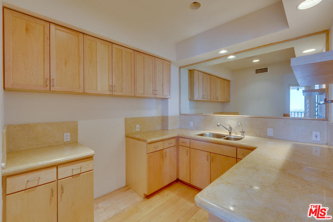 9255 Doheny Road, Unit 902 West Hollywood, CA 90069 - Photo 24 of 47 a kitchen with a sink a stove cabinets and a counter top space