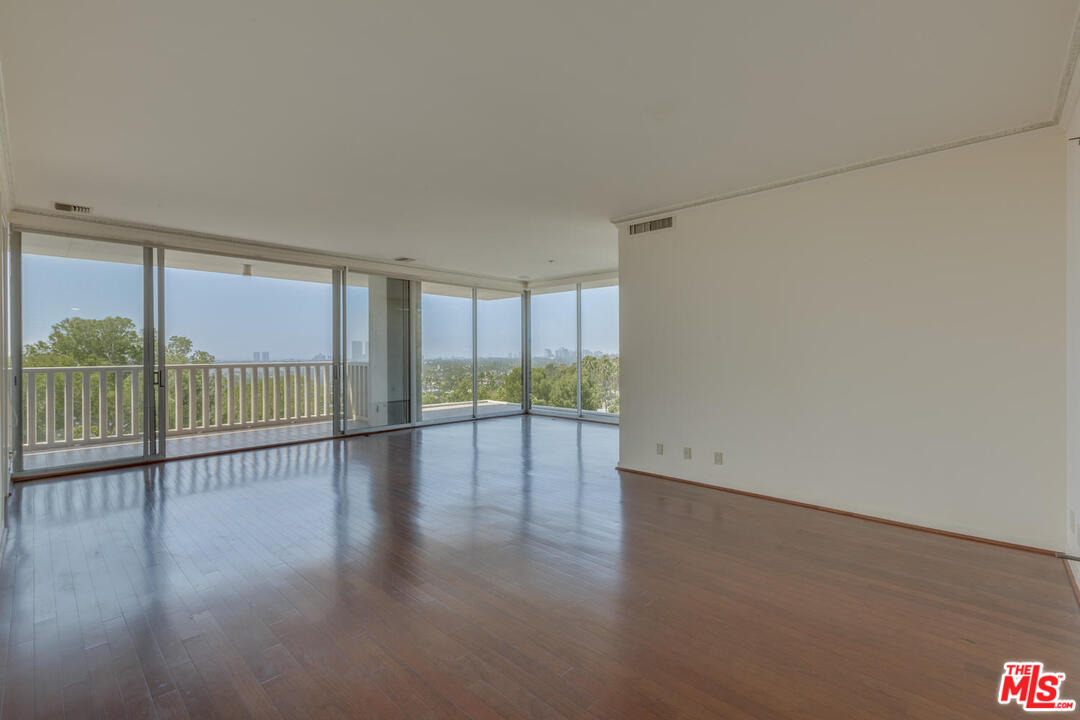 9255 Doheny Road, Unit 902 West Hollywood, CA 90069 - Photo 4 of 47 a view of an empty room with wooden floor and a window