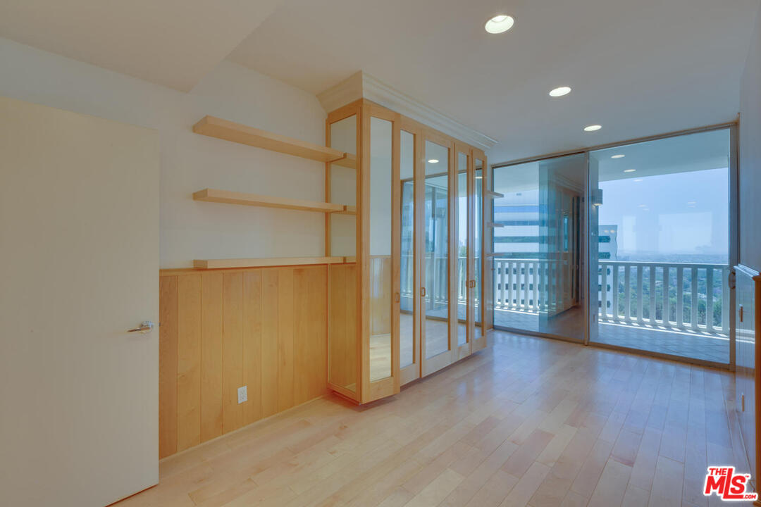 9255 Doheny Road, Unit 902 West Hollywood, CA 90069 - Photo 31 of 47 a view of an empty room with wooden floor and a window