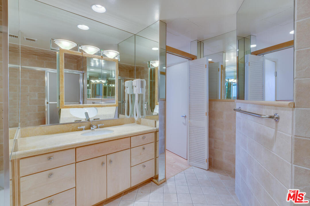 9255 Doheny Road, Unit 902 West Hollywood, CA 90069 - Photo 37 of 47 a bathroom with a shower sink and mirror