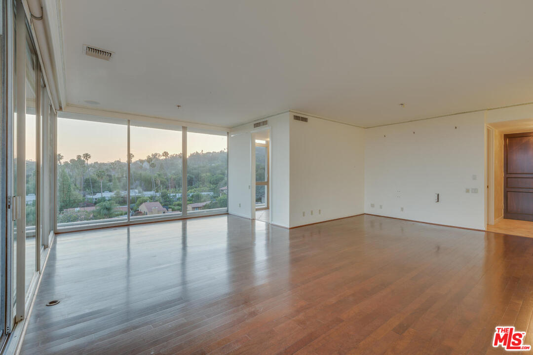 9255 Doheny Road, Unit 902 West Hollywood, CA 90069 - Photo 40 of 47 an empty room with wooden floor and windows