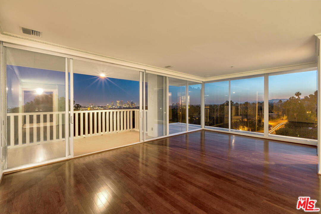 9255 Doheny Road, Unit 902 West Hollywood, CA 90069 - Photo 42 of 47 an empty room with wooden floor and windows