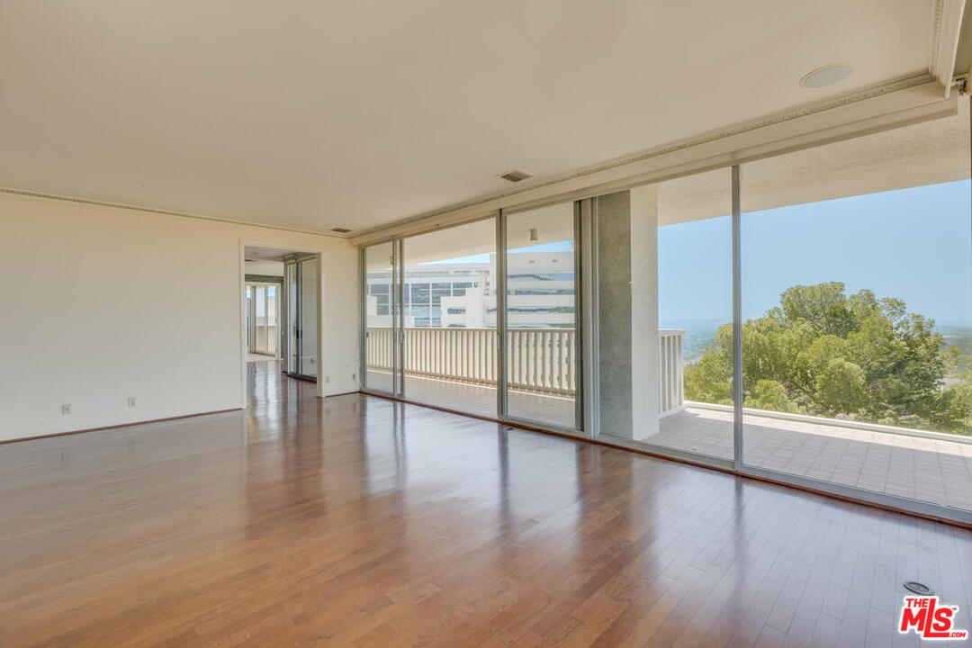 9255 Doheny Road, Unit 902 West Hollywood, CA 90069 - Photo 7 of 47 a view of an empty room with wooden floor and a window