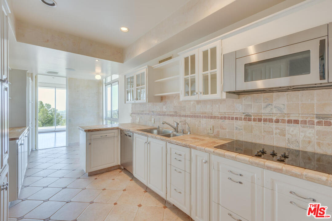 9255 Doheny Road, Unit 902 West Hollywood, CA 90069 - Photo 10 of 47 a kitchen with granite countertop a sink and cabinets