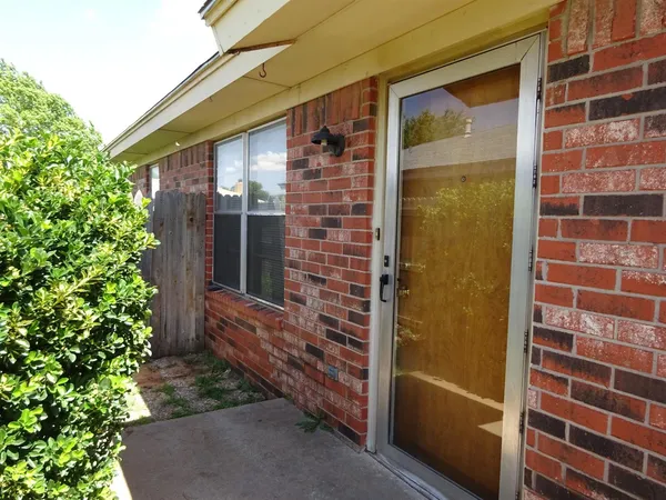 a view of front door of house with potted plants