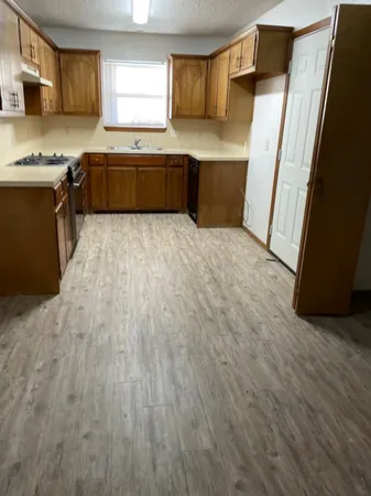 a kitchen with stainless steel appliances granite countertop a stove a sink and a refrigerator