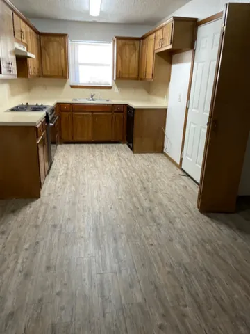 a kitchen with stainless steel appliances granite countertop a stove a sink and a refrigerator