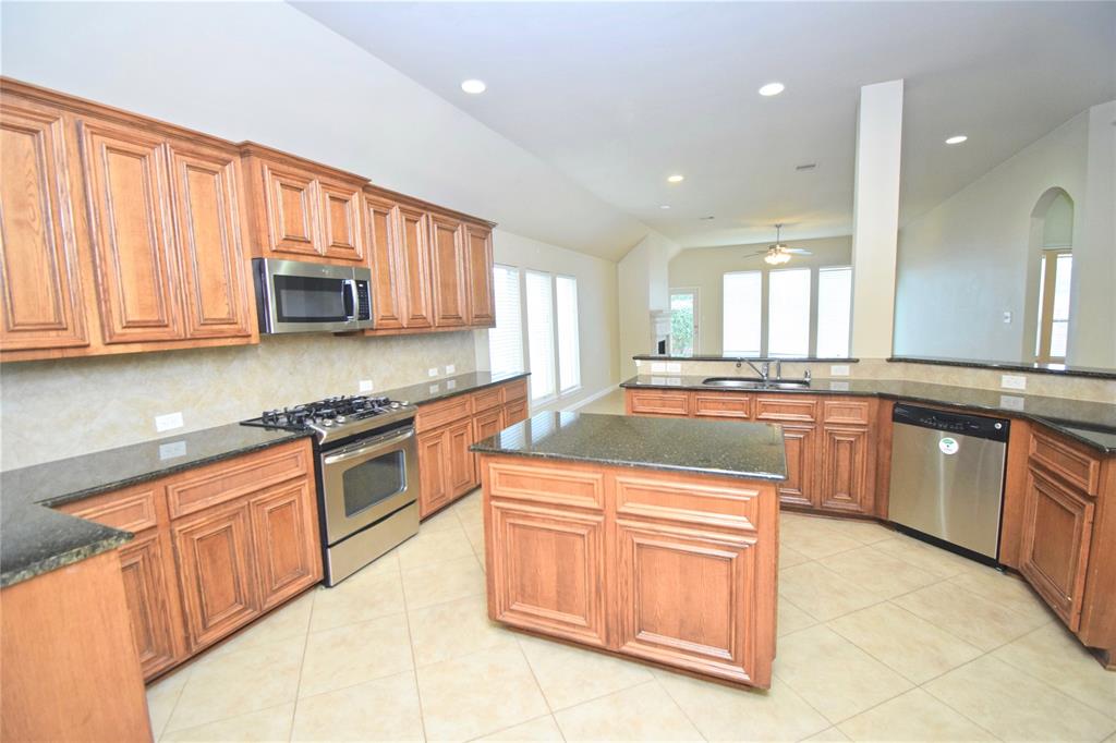 View of the spacious island kitchen featuring stainless steel appliances and granite countertops.