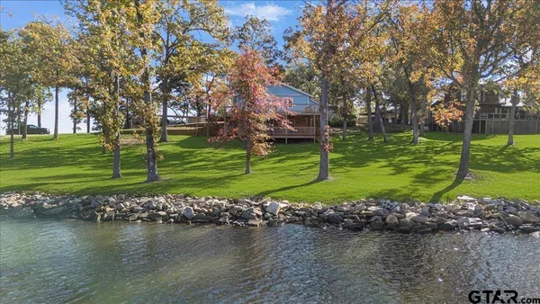 a view of swimming pool with seating area and lake view
