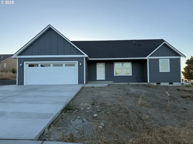 a view of a big house with wooden fence