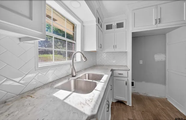 a kitchen with granite countertop a sink and a stove top oven